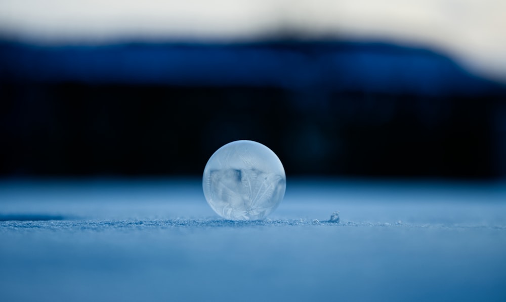 clear glass ball on white surface