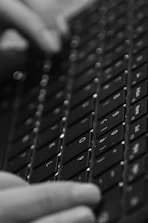 Close-up of hands typing on a keyboard with stone taupe and charcoal black tones.