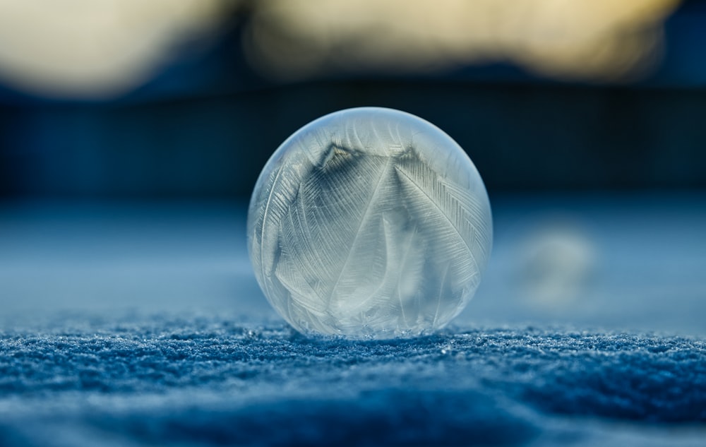 white and blue glass ball on white and blue textile