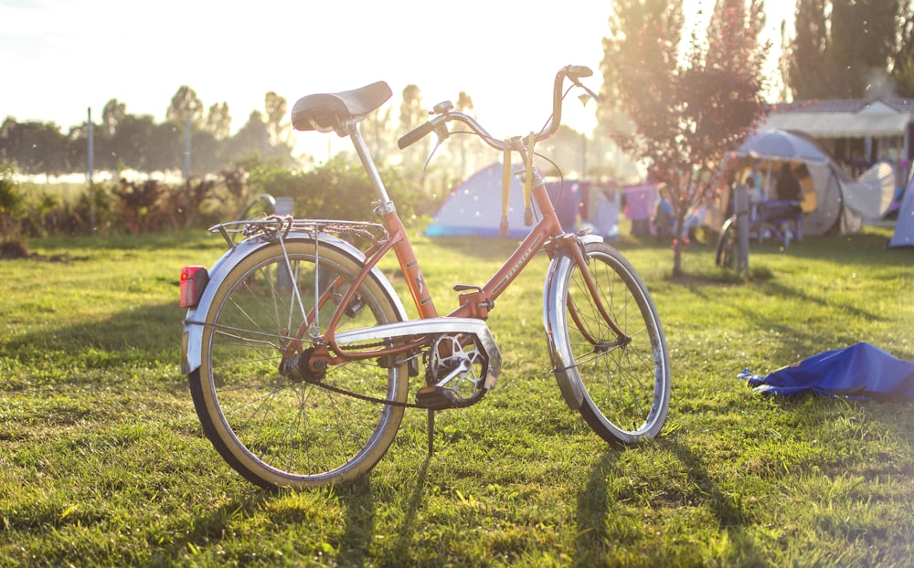 red and white city bike on green grass field during daytime