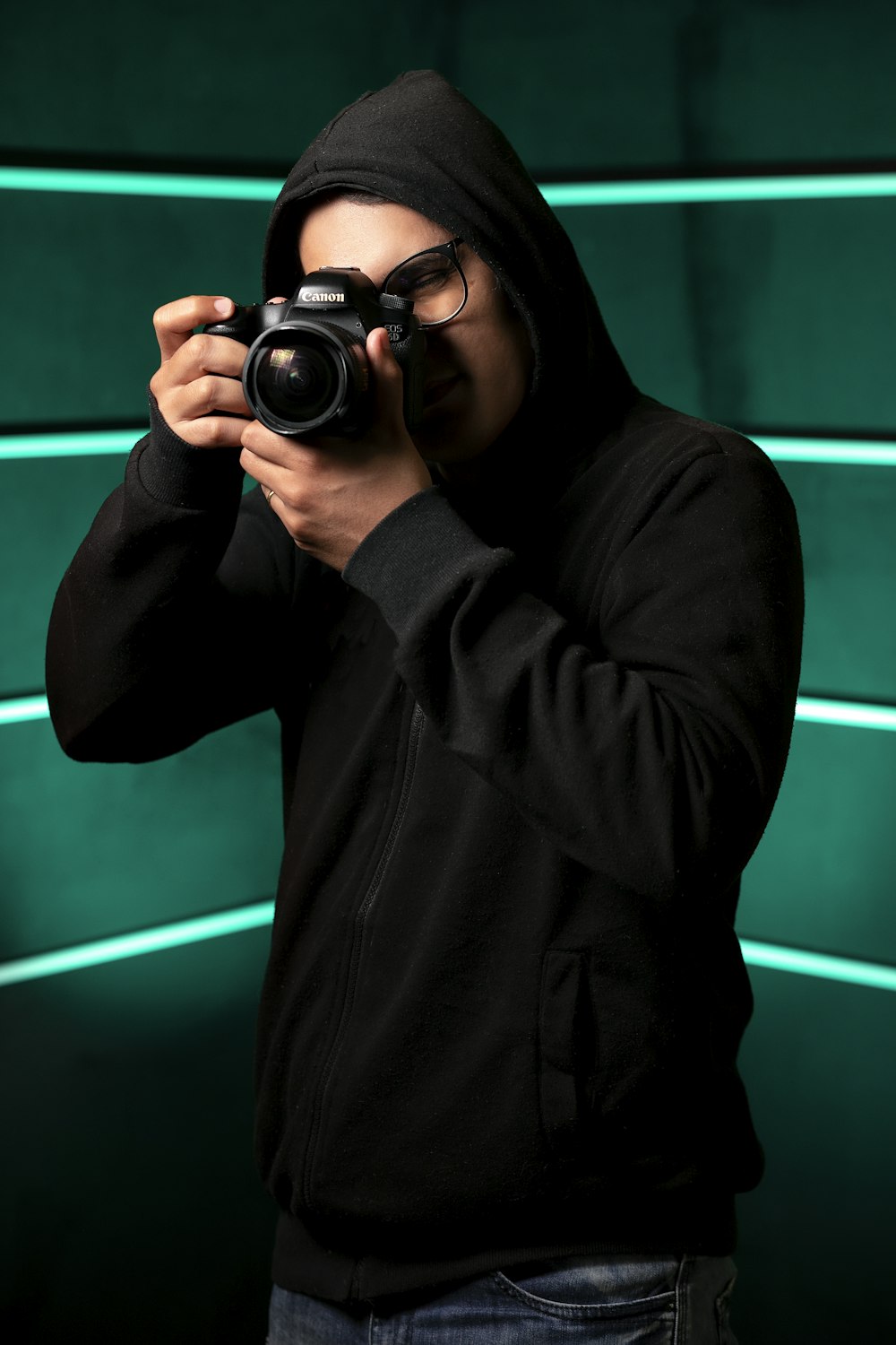 woman in black hoodie holding black dslr camera