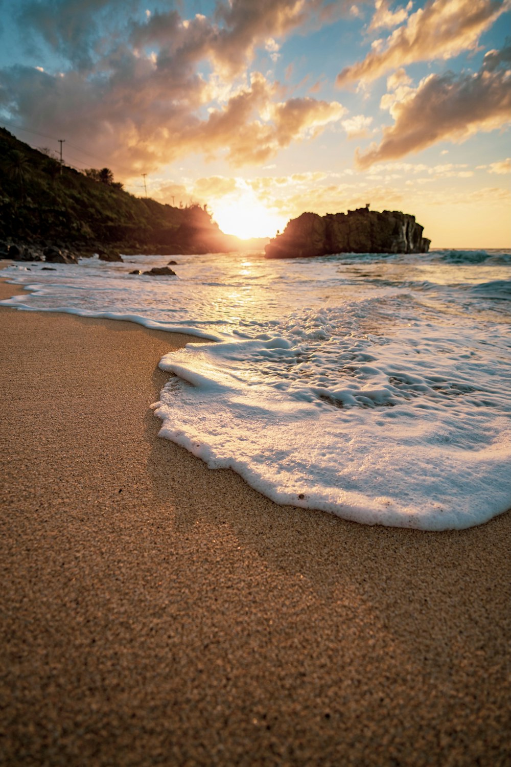 sea waves crashing on shore during sunset