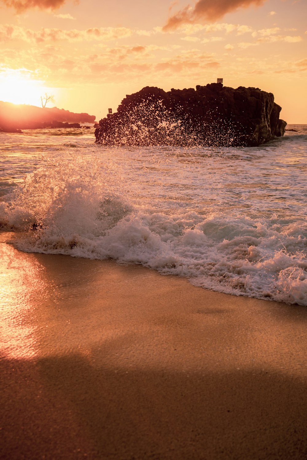 ocean waves crashing on shore during sunset