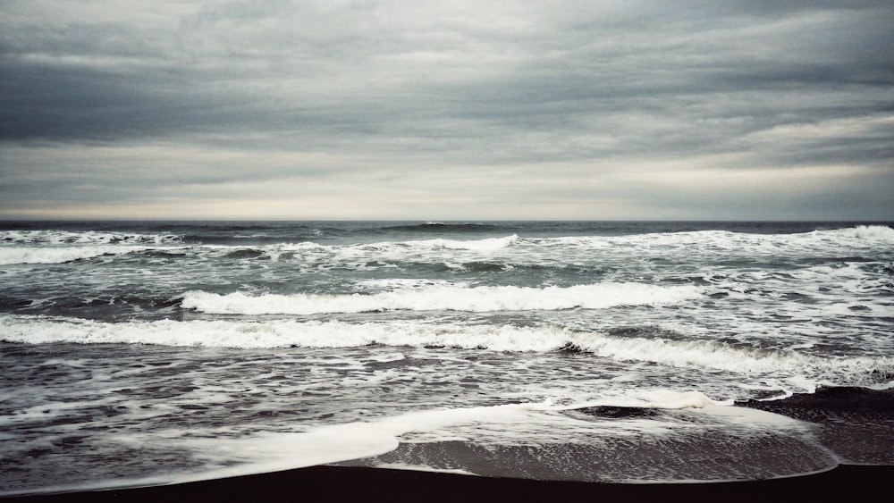 ocean waves crashing on shore during daytime