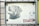 A metal sign attached to a gate features two printed dog images. The larger image depicts a black Labrador with its mouth open, and the smaller image shows a white dog with black spots. The background is off-white and appears slightly weathered. Below the images, there is a red and white label that reads 'HAPPY DOG'.