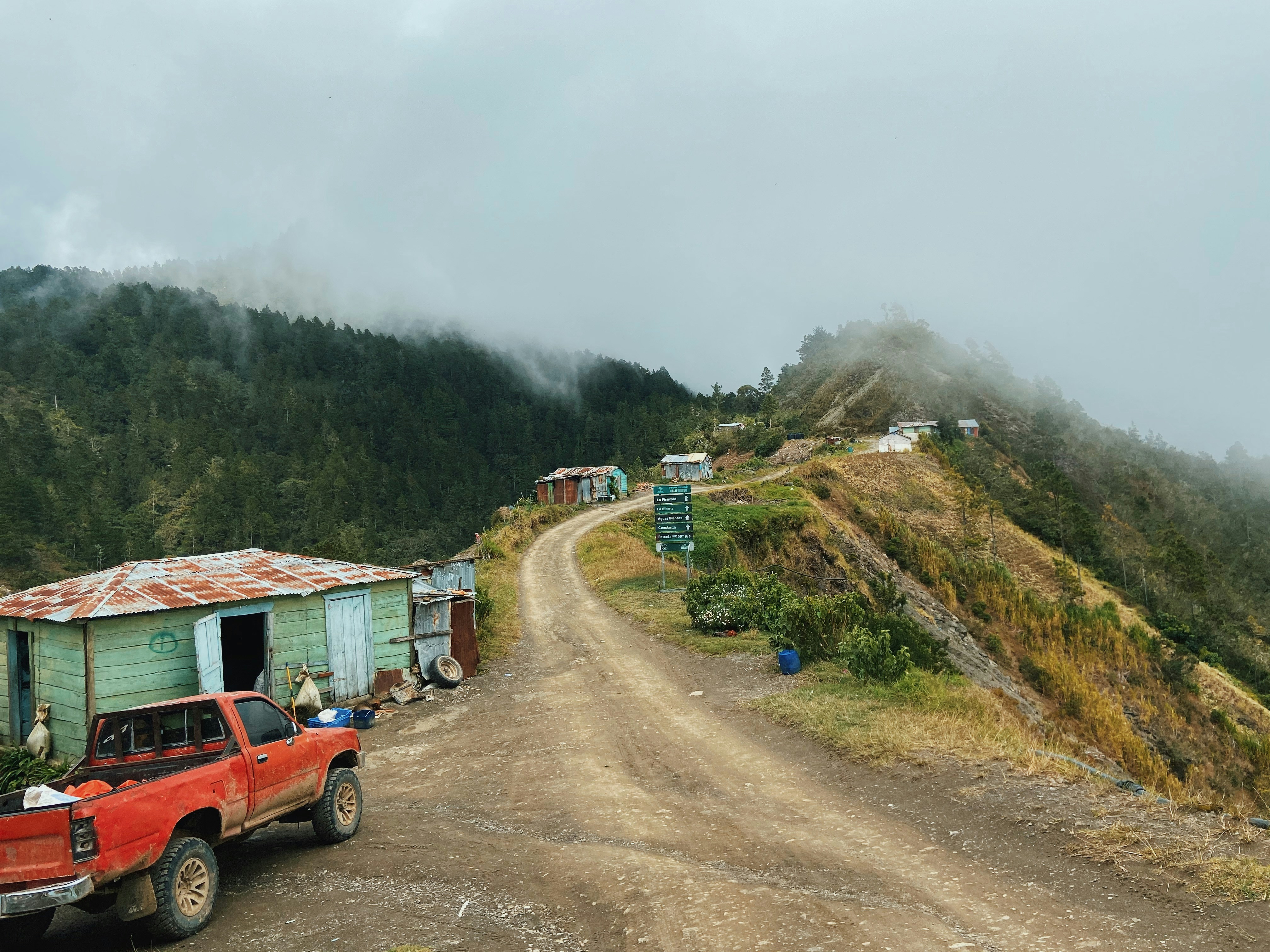 red suv on dirt road near green grass field during daytime