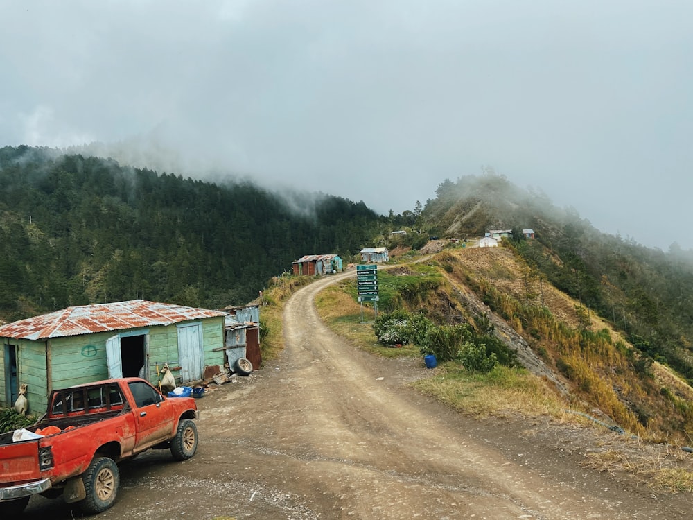 red suv on dirt road near green grass field during daytime