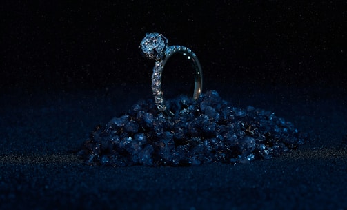 A sparkling diamond ring set against a soft, dark background highlighting its brilliance.