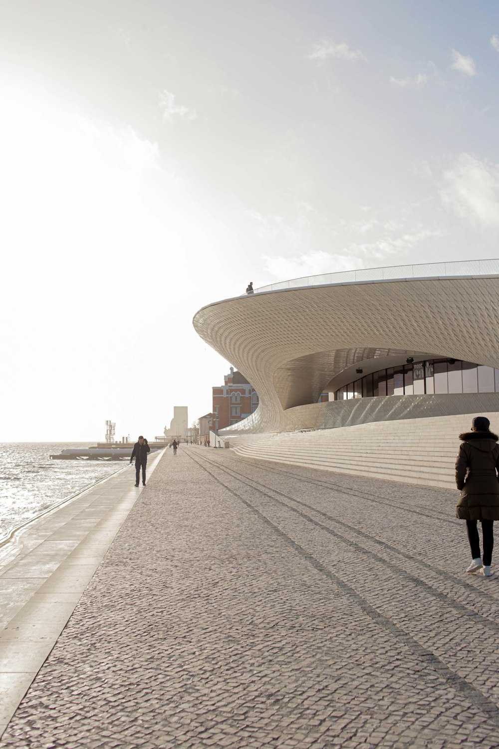 people walking on white concrete building near sea during daytime