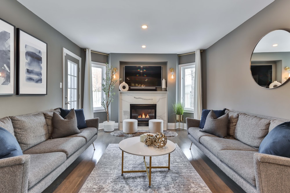 gray couch near white fireplace