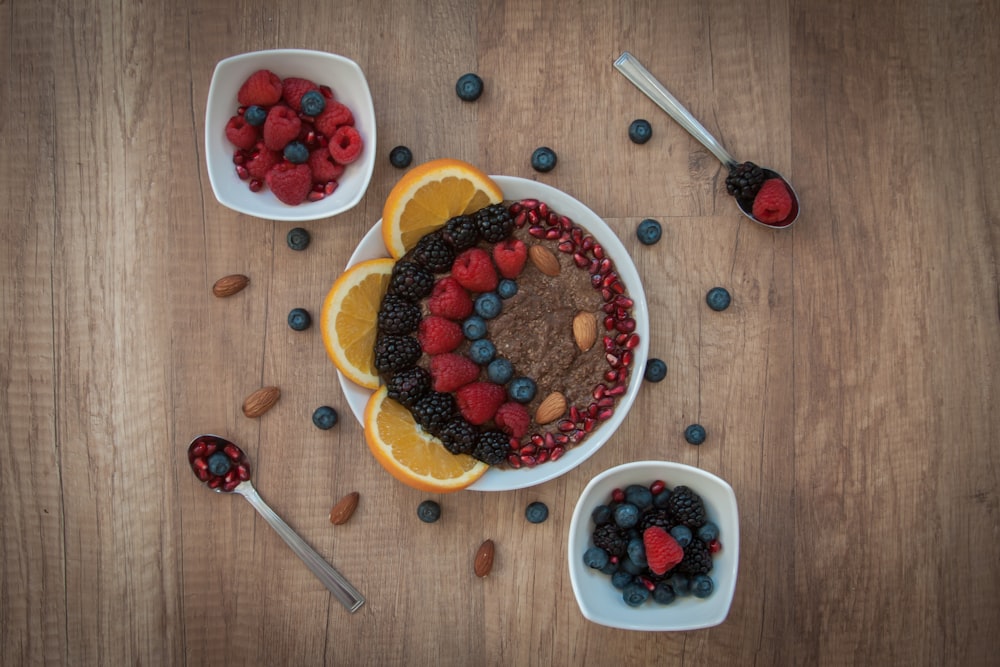 sliced strawberries and blueberries on white ceramic bowl