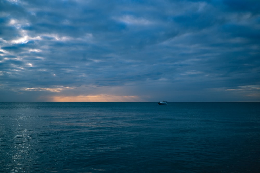 Bateau sur la mer sous le ciel bleu et les nuages blancs pendant la journée