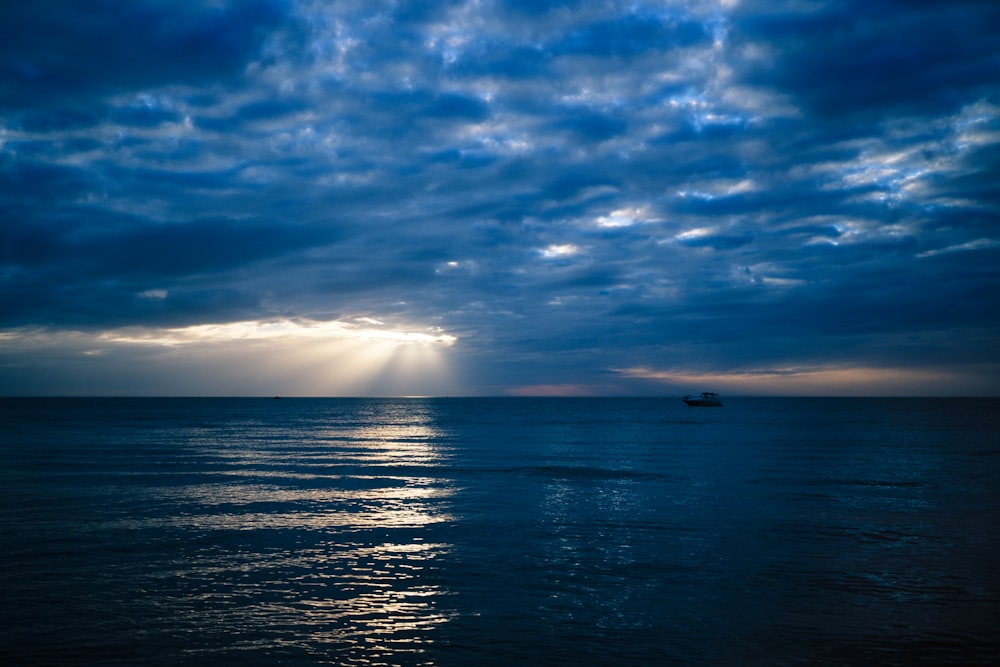 specchio d'acqua sotto cielo blu e nuvole bianche durante il giorno