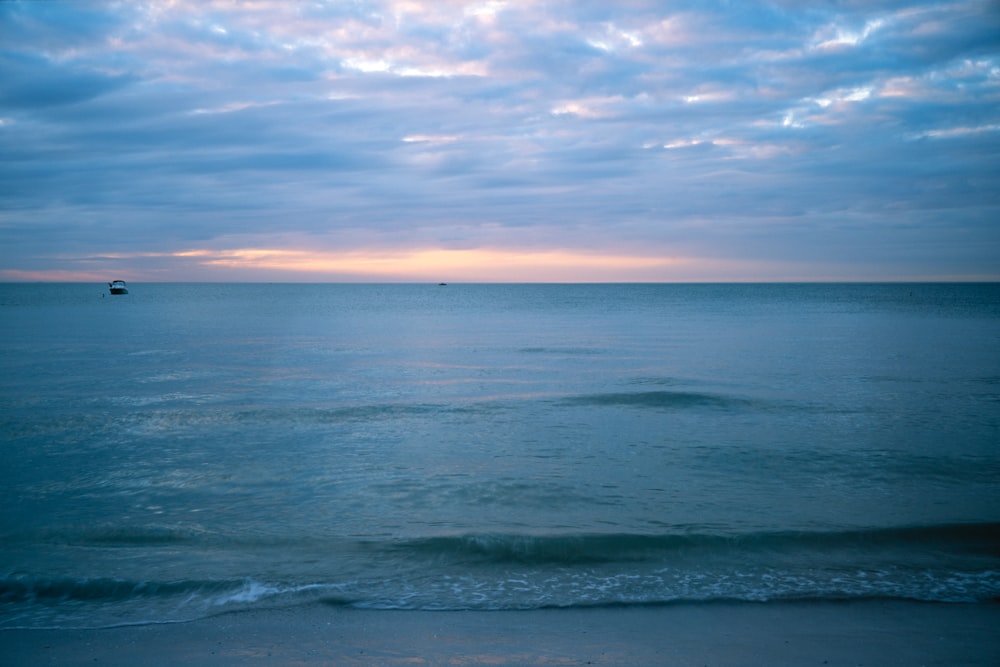 onde dell'oceano sotto il cielo nuvoloso durante il giorno