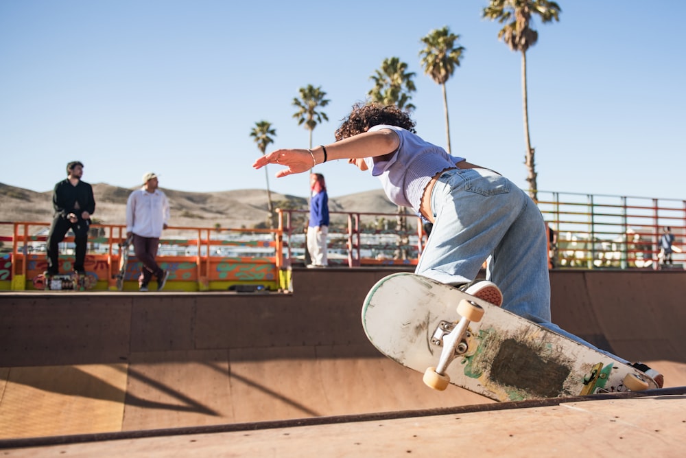 man in blue t-shirt and blue denim jeans riding skateboard during daytime