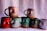 A collection of uniquely designed ceramic mugs, each featuring a raised, abstract sculpture on the side resembling human torsos. The mugs are arranged in two rows against a plain backdrop, showcasing various colors including pink, red, green, and grey.