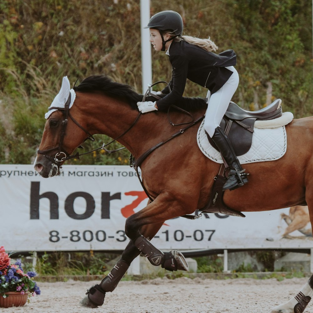 man in black and white jacket riding brown horse during daytime