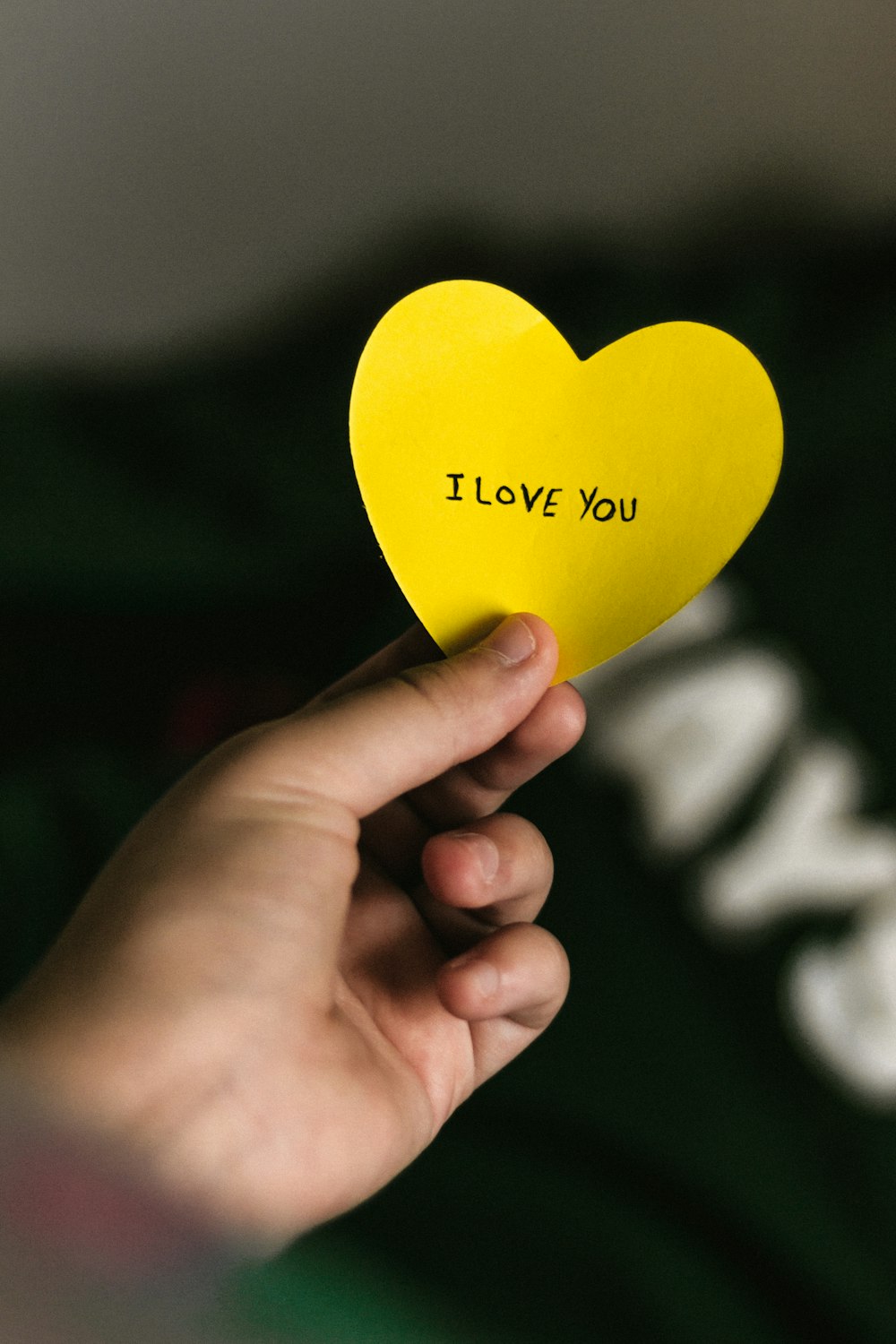 person holding yellow heart paper