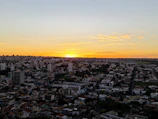 A vibrant sunset over a city skyline captured by drone, highlighting warm golden hues.