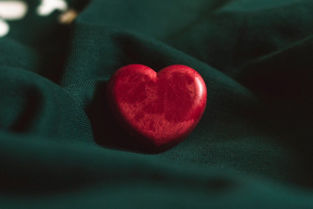 red heart ornament on green textile