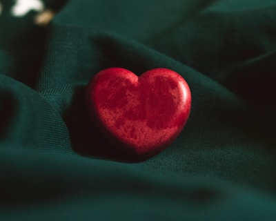 red heart ornament on green textile