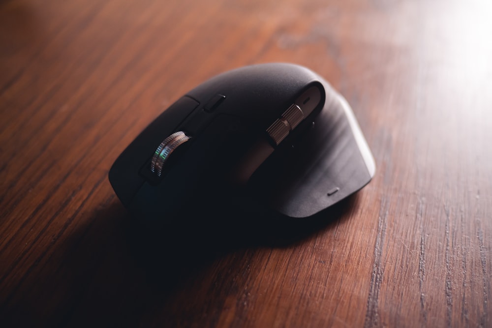 black cordless computer mouse on brown wooden table