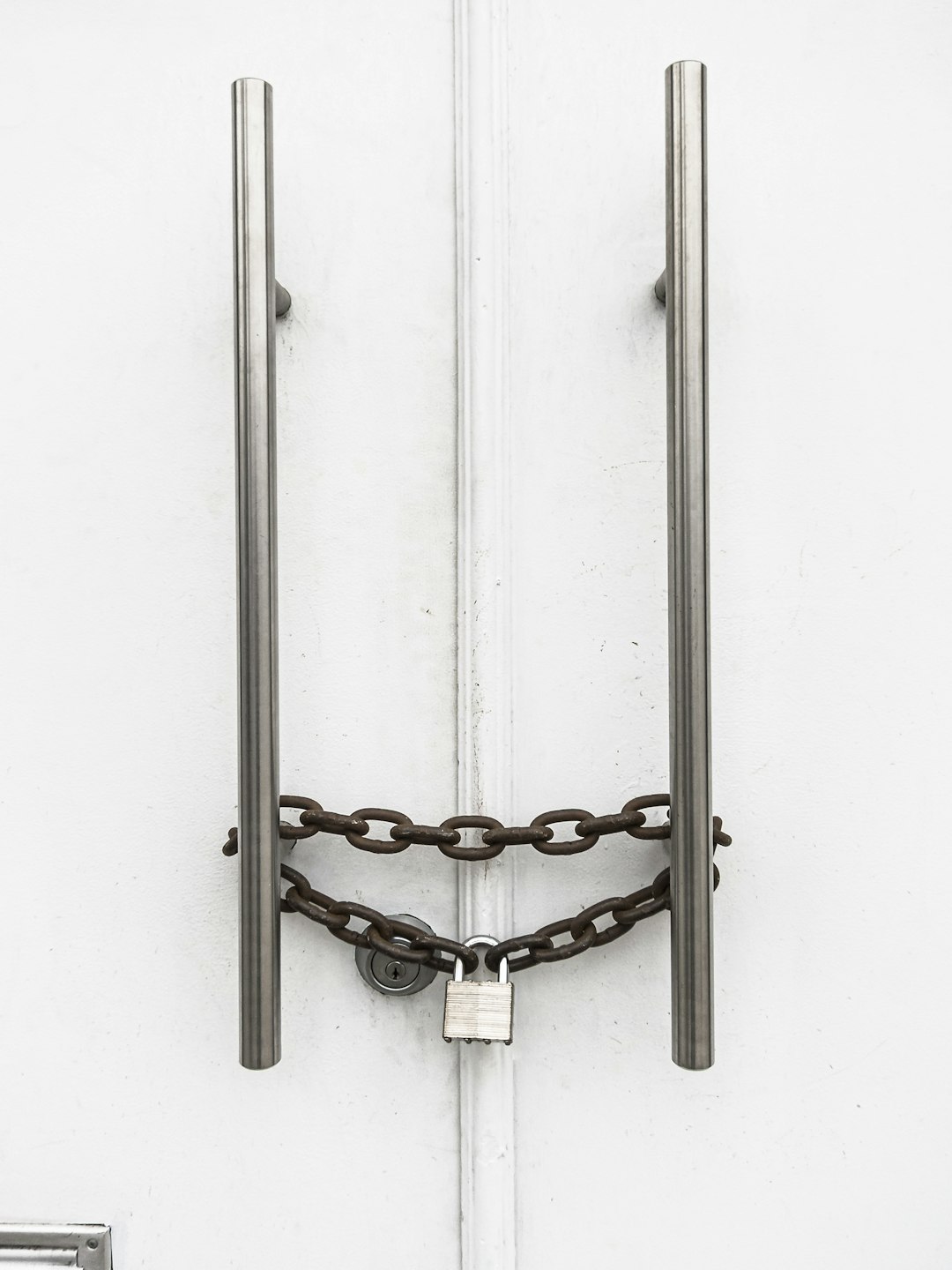  silver chain on white wooden door safe