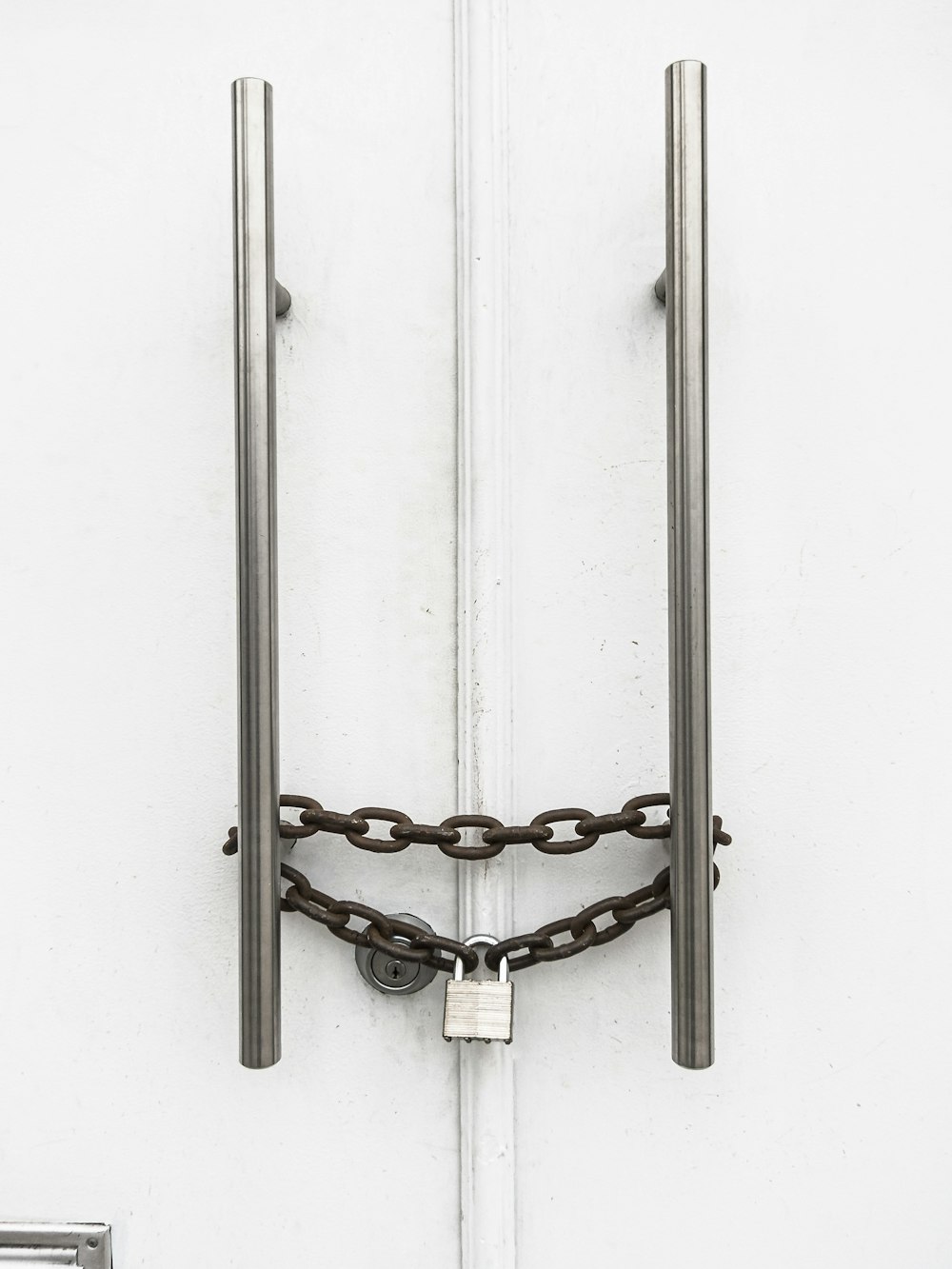 silver chain on white wooden door