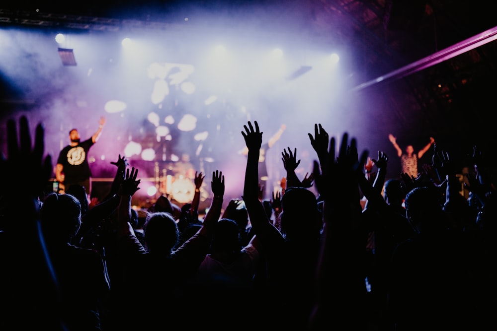 people raising their hands in front of crowd