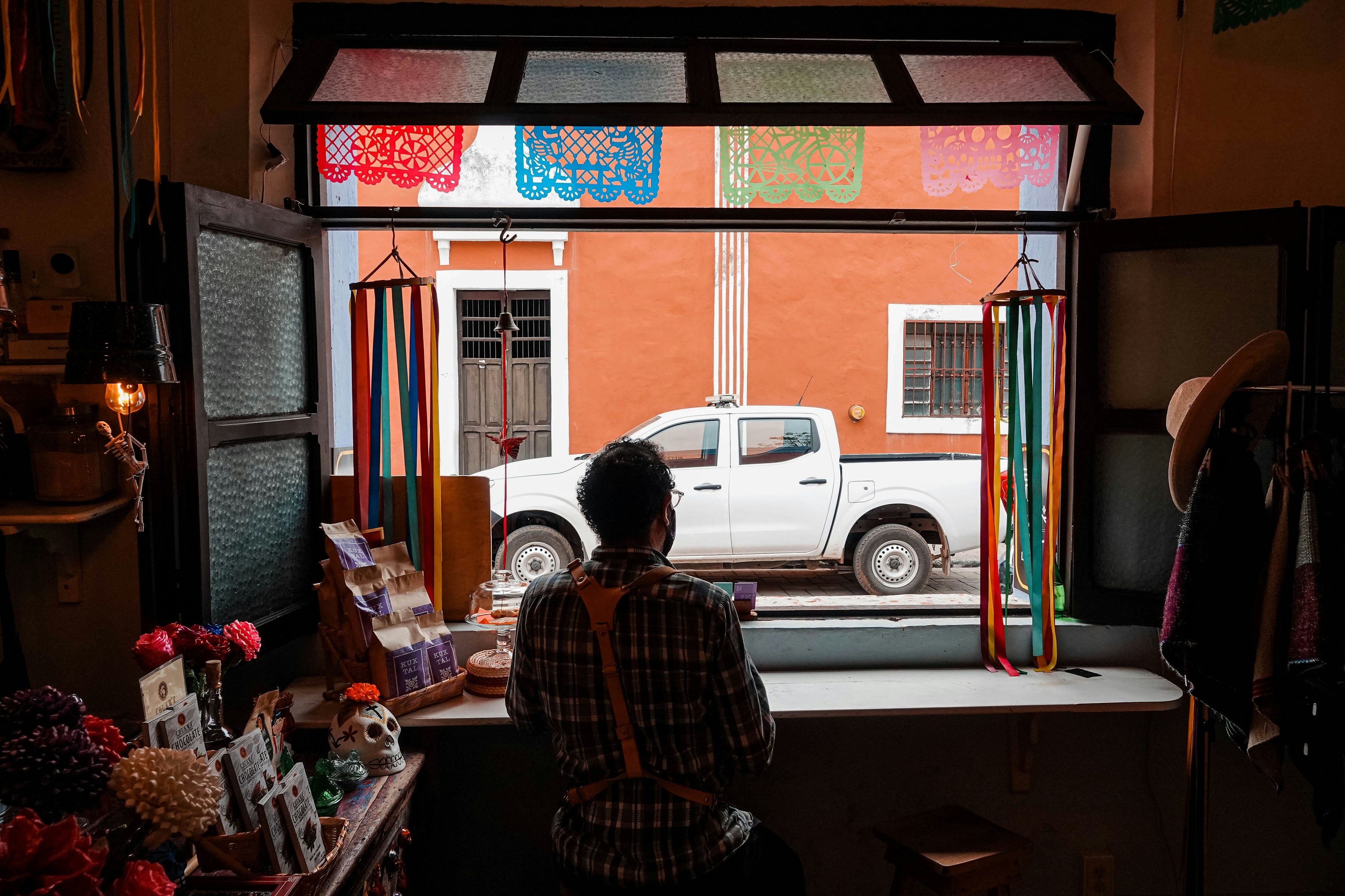 woman in black and white plaid dress shirt sitting on brown wooden bench