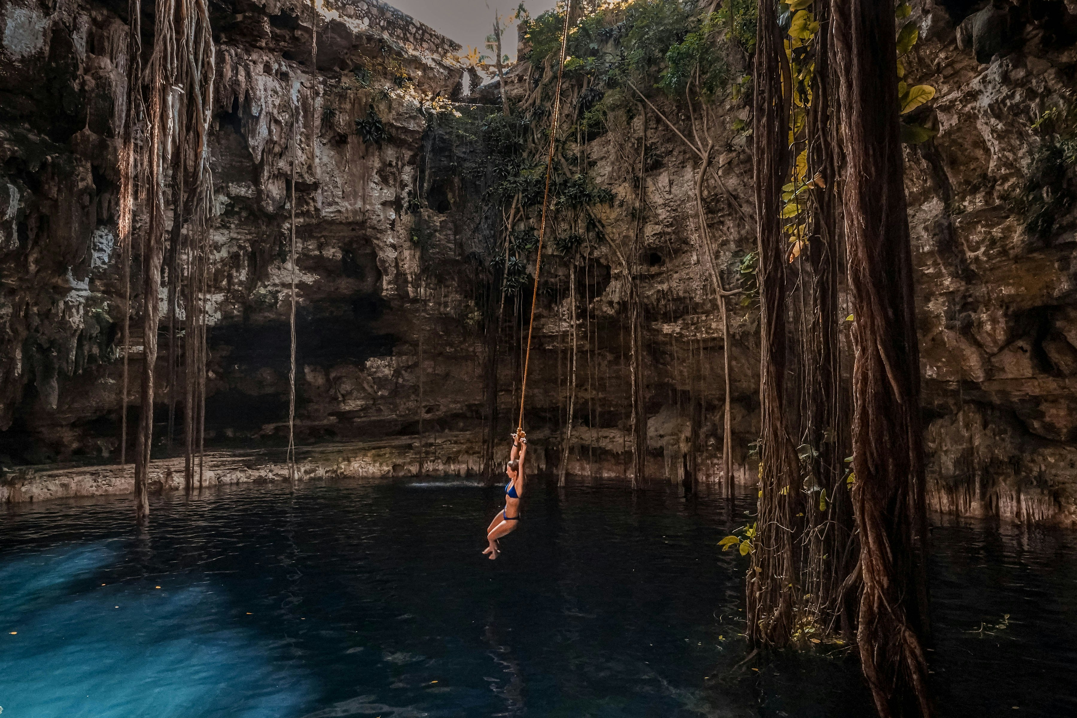 una viaggiatrice si tuffa in un cenote, uno dei posti dove andare in messico per un viaggio indimenticabile