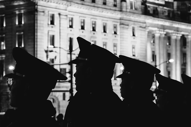 Professional security personnel standing alert outside a commercial building at dusk.