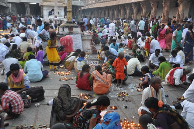 A vibrant, colorful gathering of people engaged in a joyful prayer circle under warm, glowing lights.