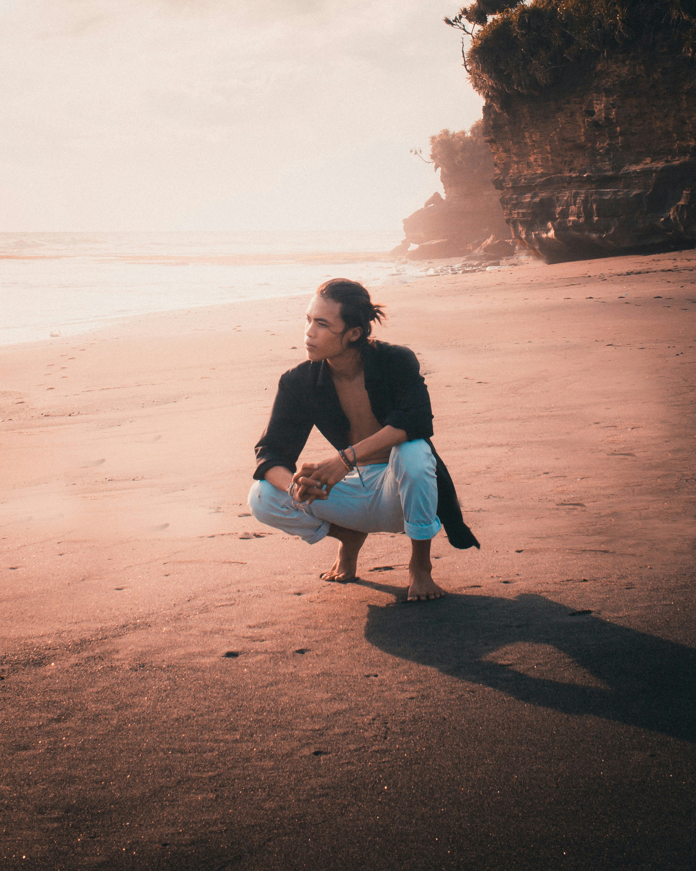woman in black long sleeve shirt sitting on rock formation during daytime