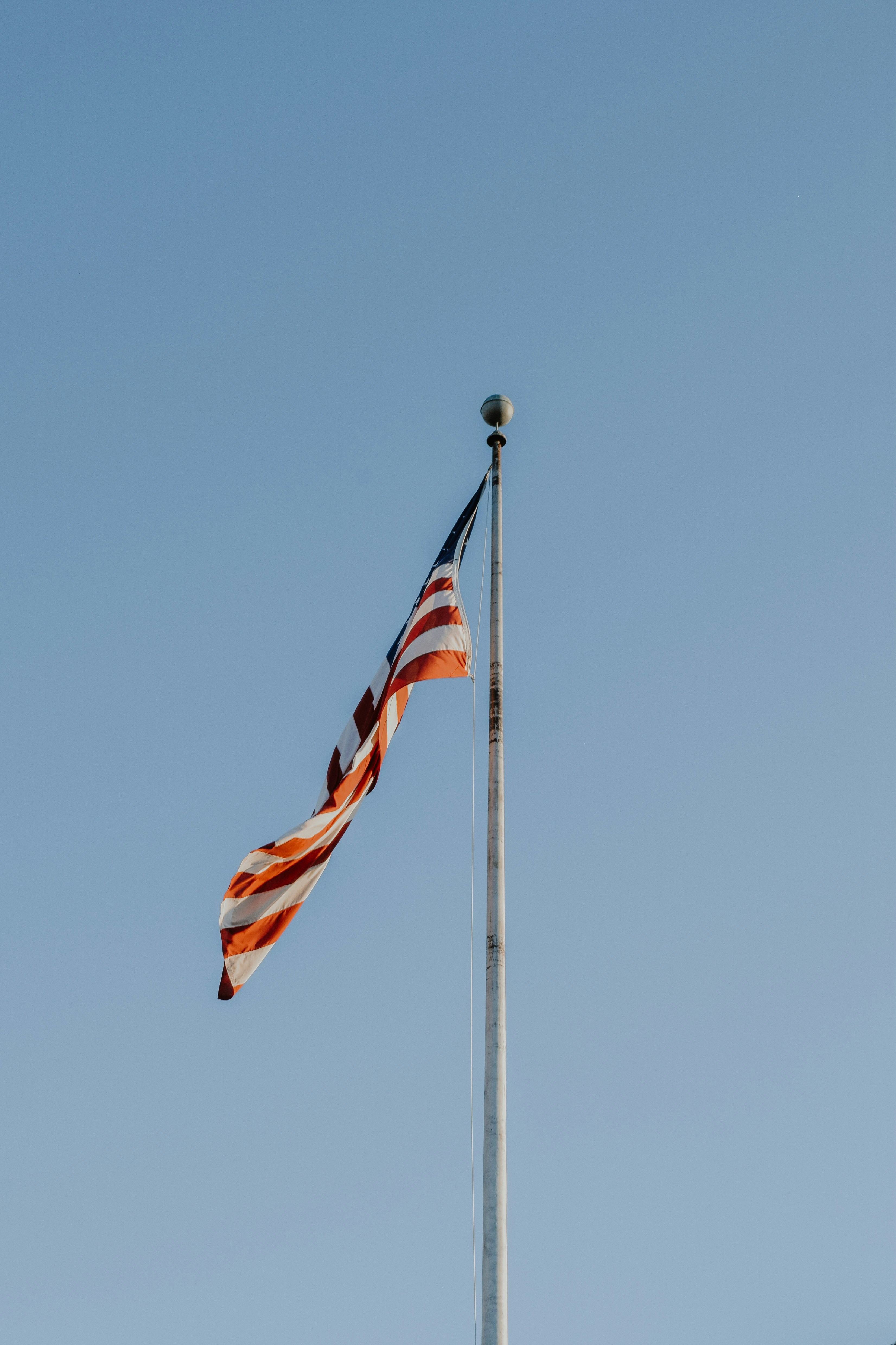 us a flag on flag pole during daytime