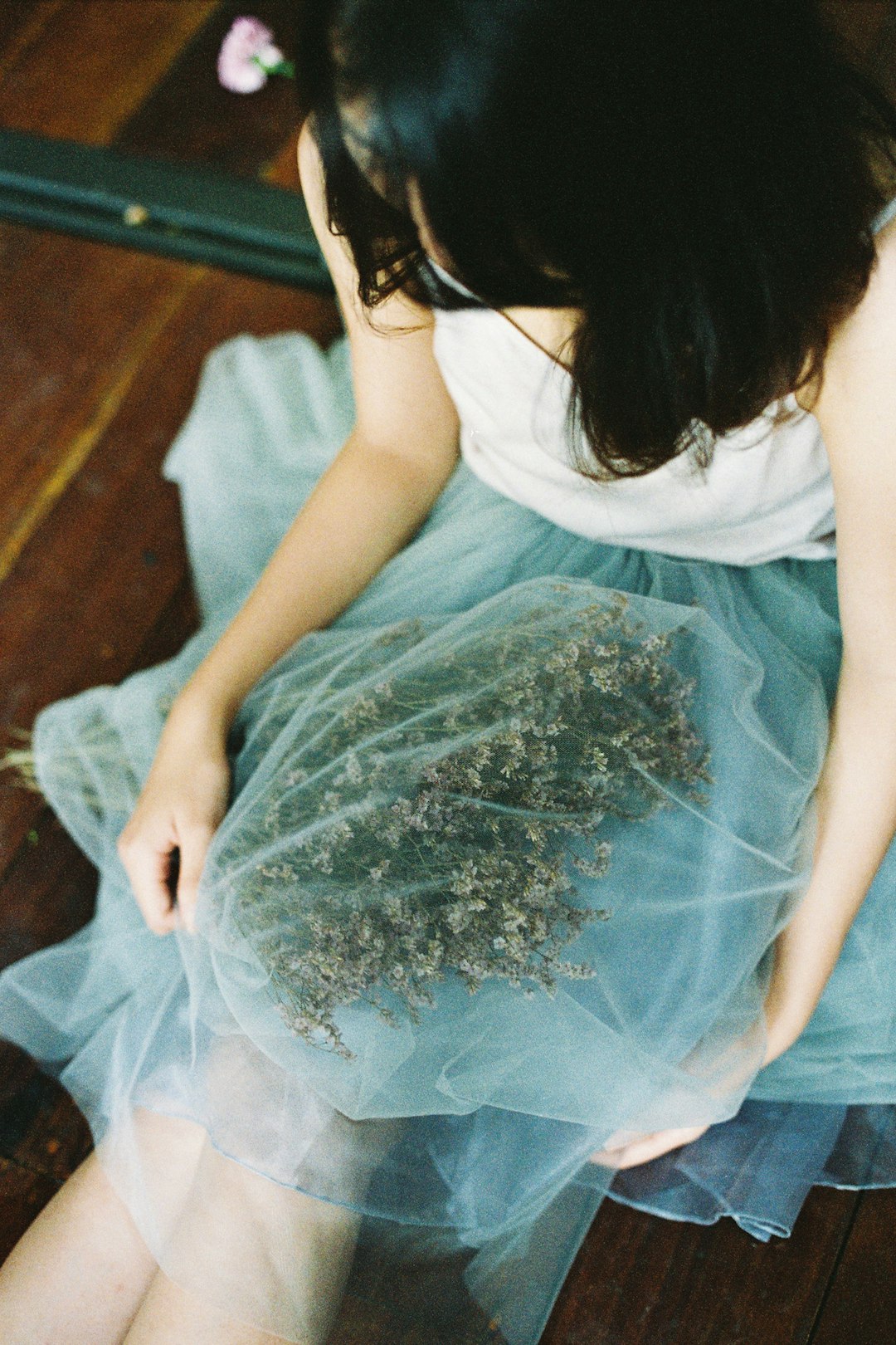 woman in teal dress sitting on bed