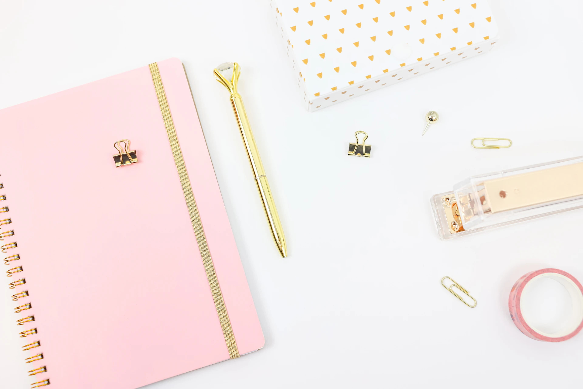 gold pen beside pink book