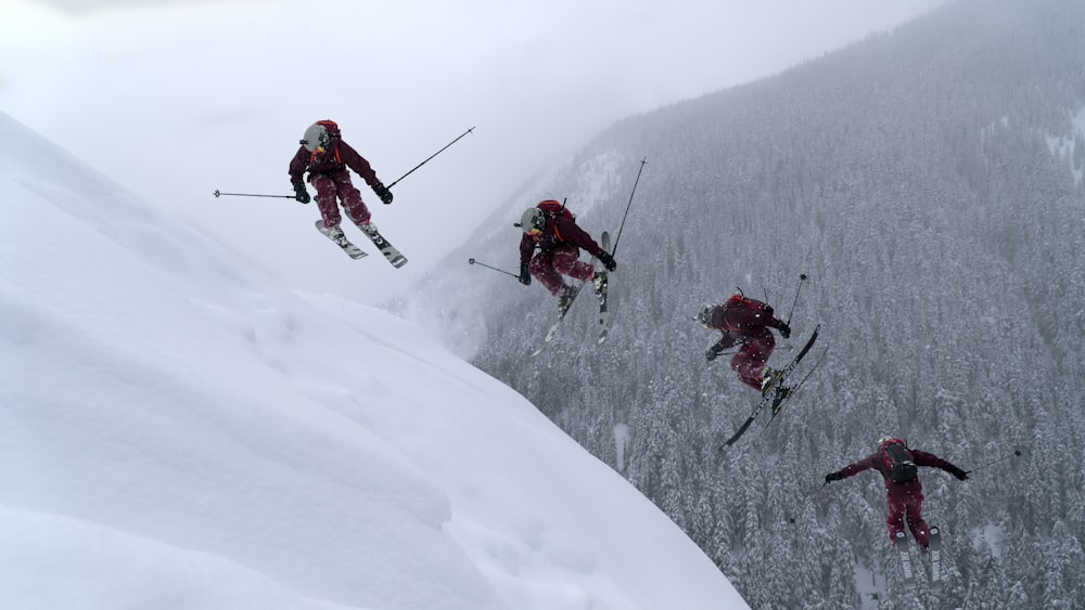 people in red jacket and black pants riding ski blades on snow covered mountain during daytime
