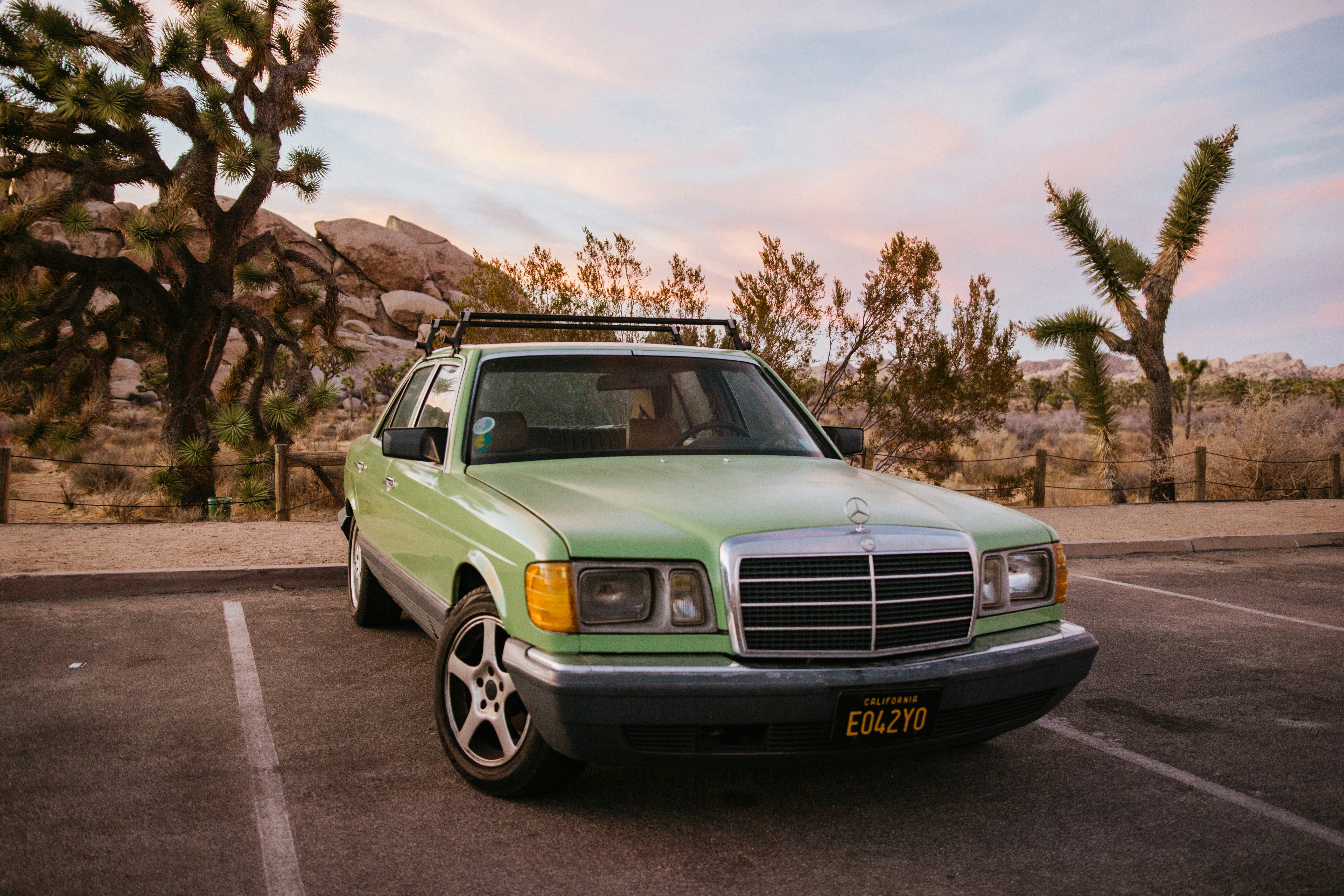 green chevrolet car parked on gray asphalt road during daytime