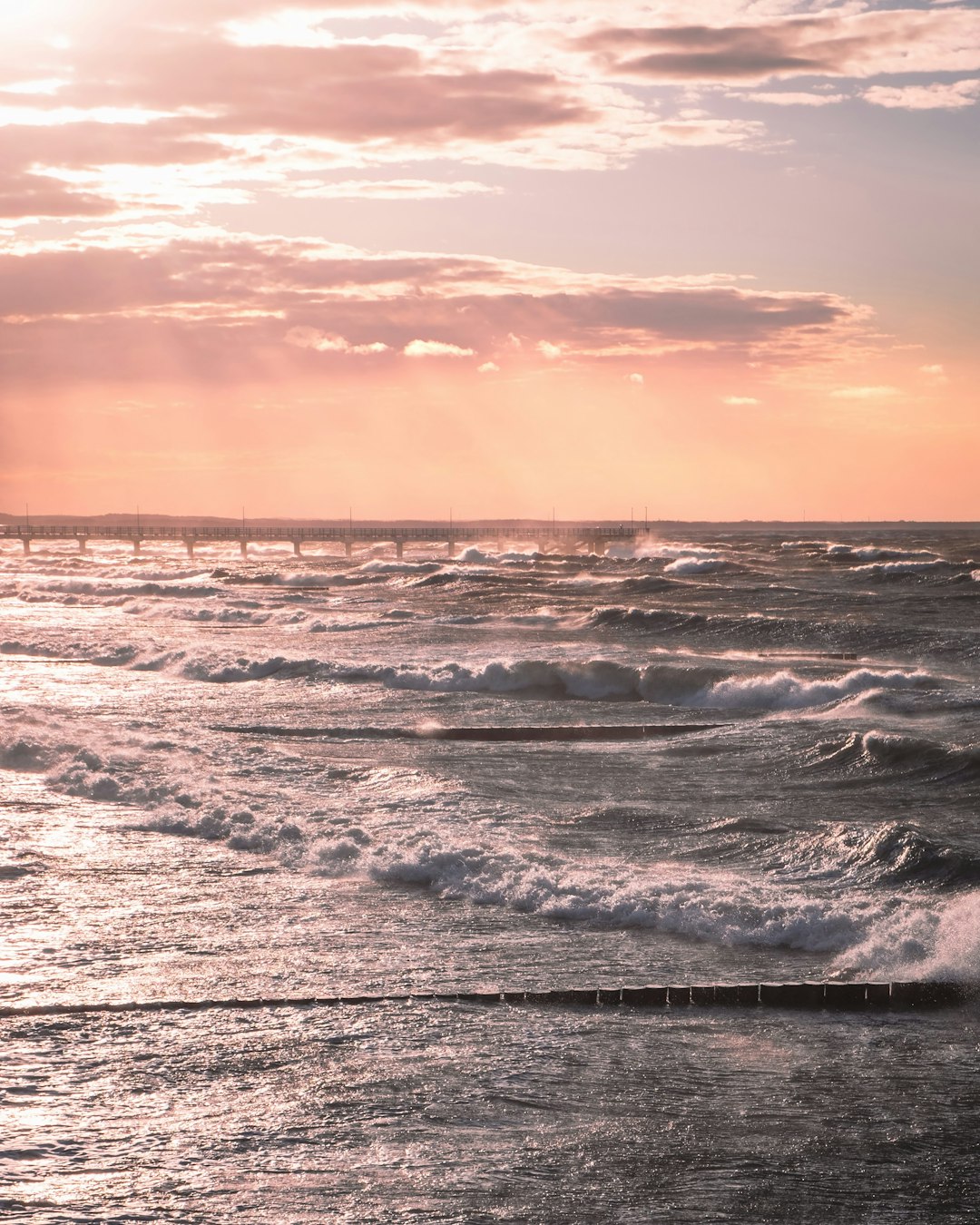 sea waves crashing on shore during sunset