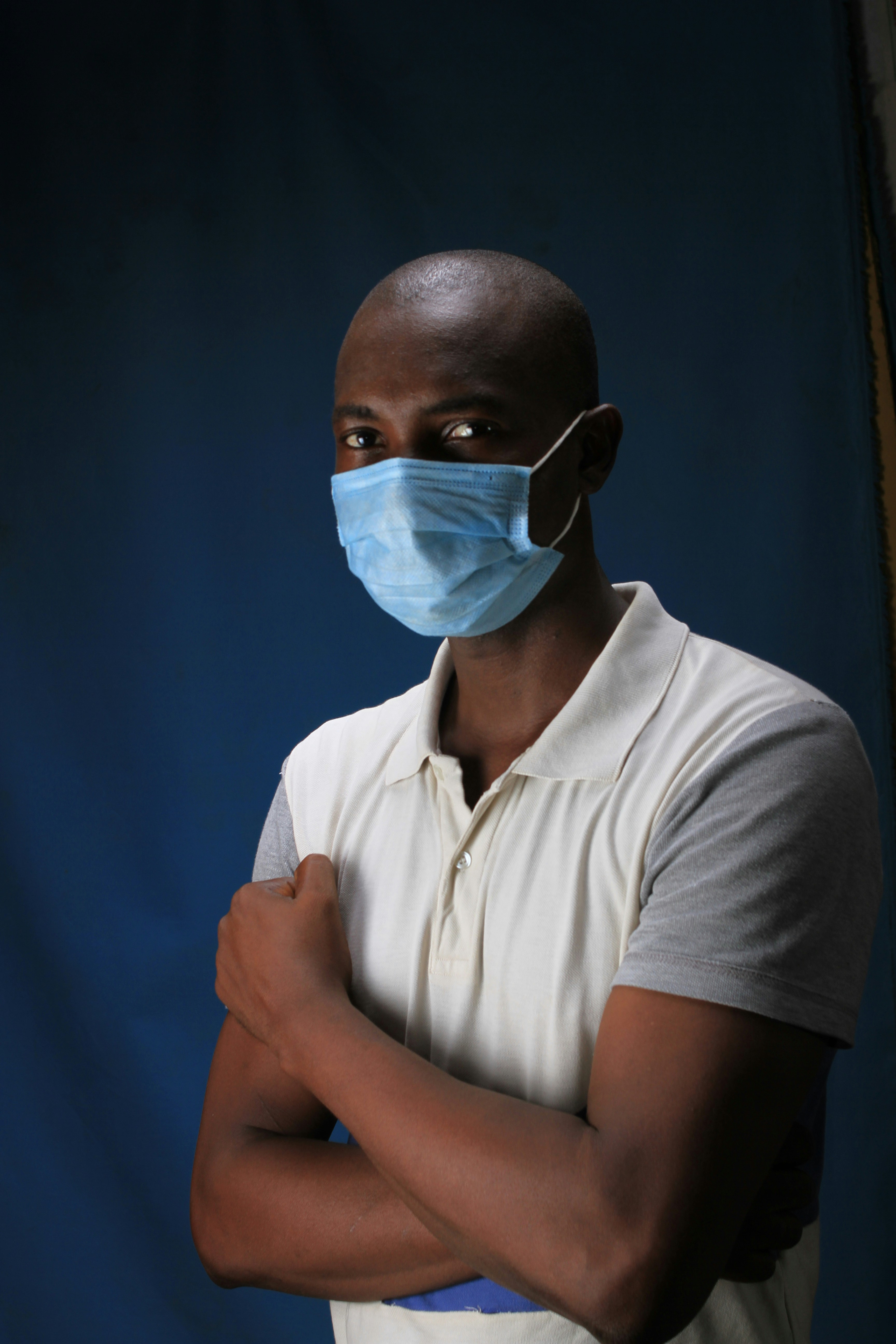 man in white polo shirt wearing white mask