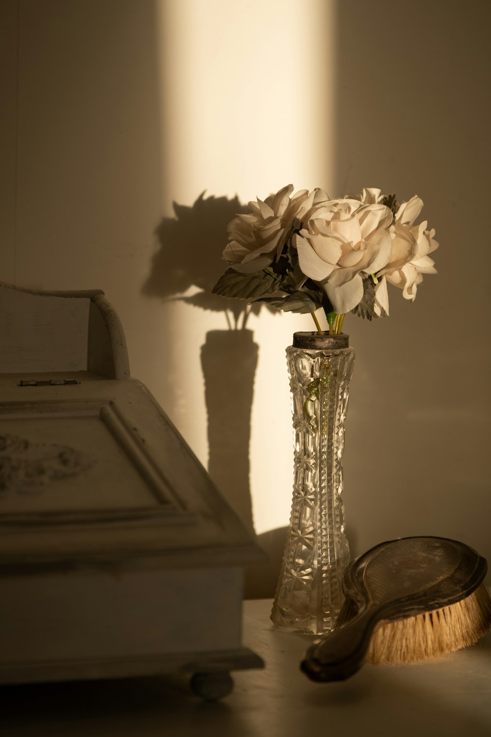 white flower in clear glass vase on brown wooden table