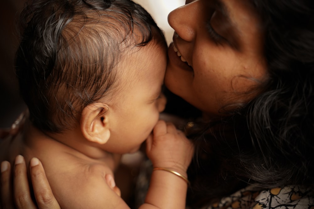 femme embrassant bébé sur la joue