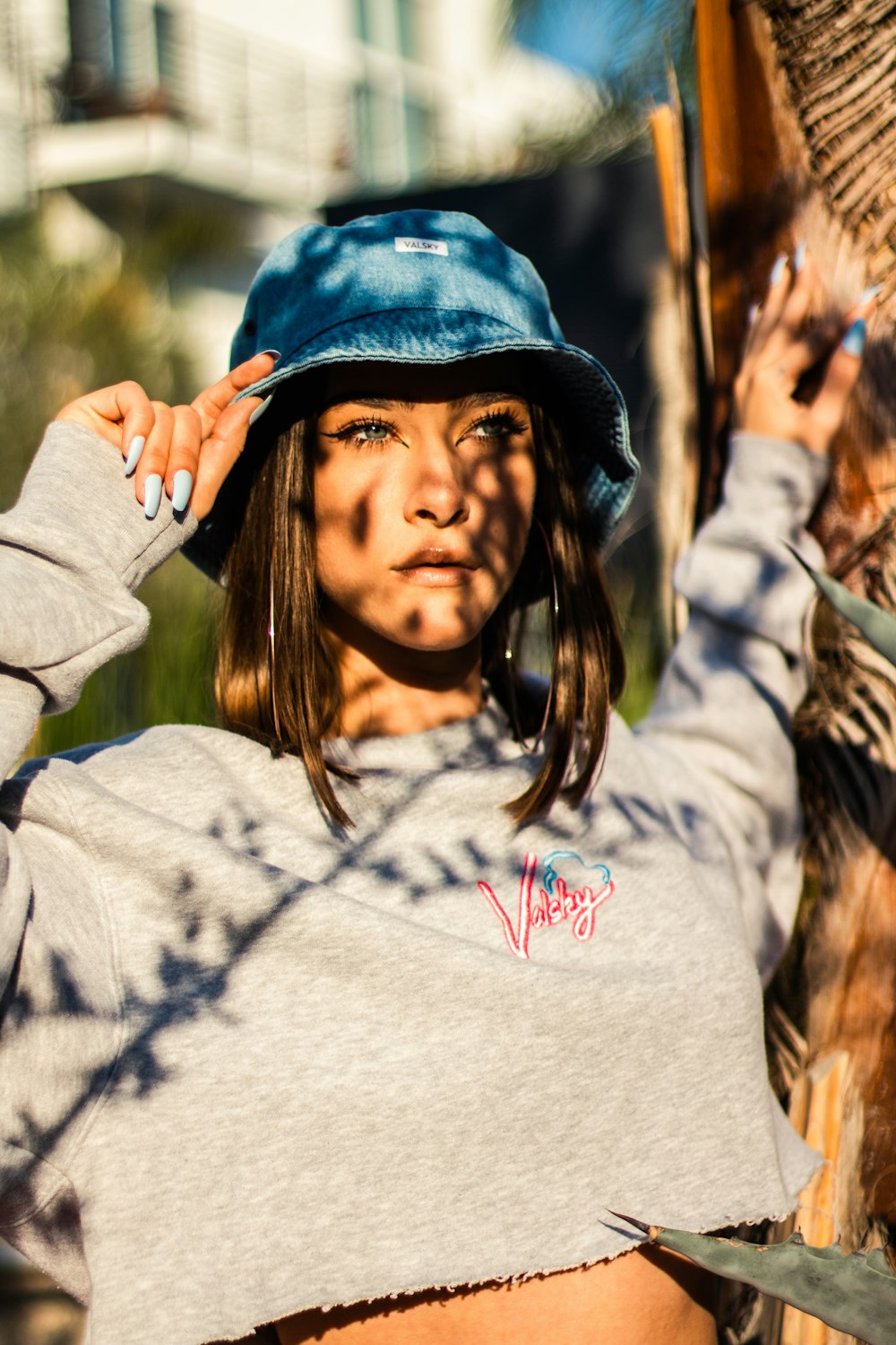 woman in white and pink sweater wearing blue cap