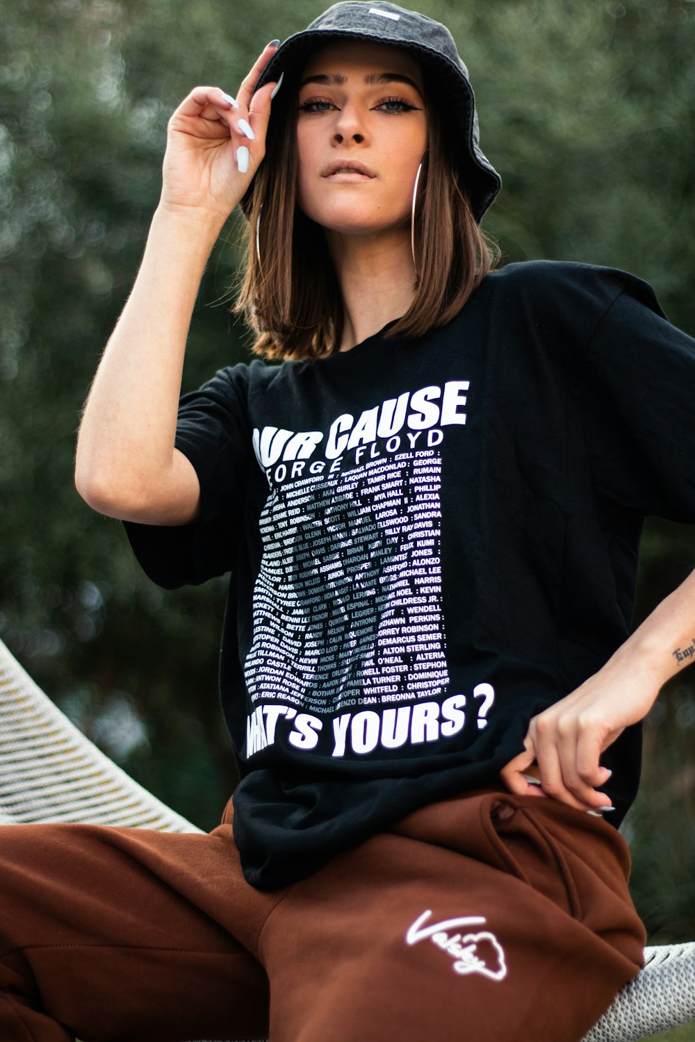 woman in black and white crew neck t-shirt and brown pants sitting on white hammock