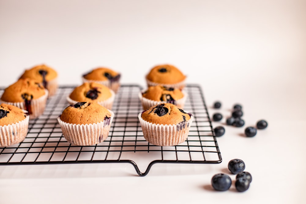 three brown and black cupcakes on white tray