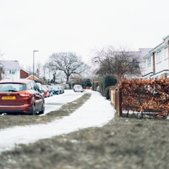 red car on snow covered road during daytime