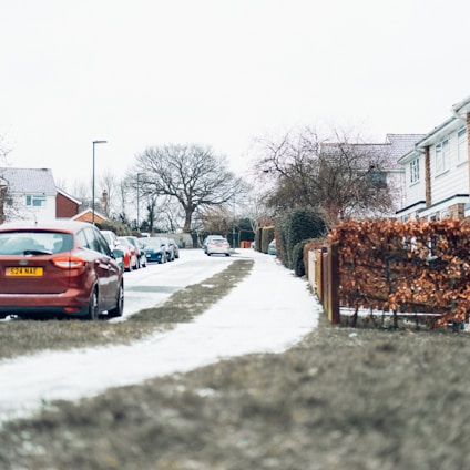 red car on snow covered road during daytime