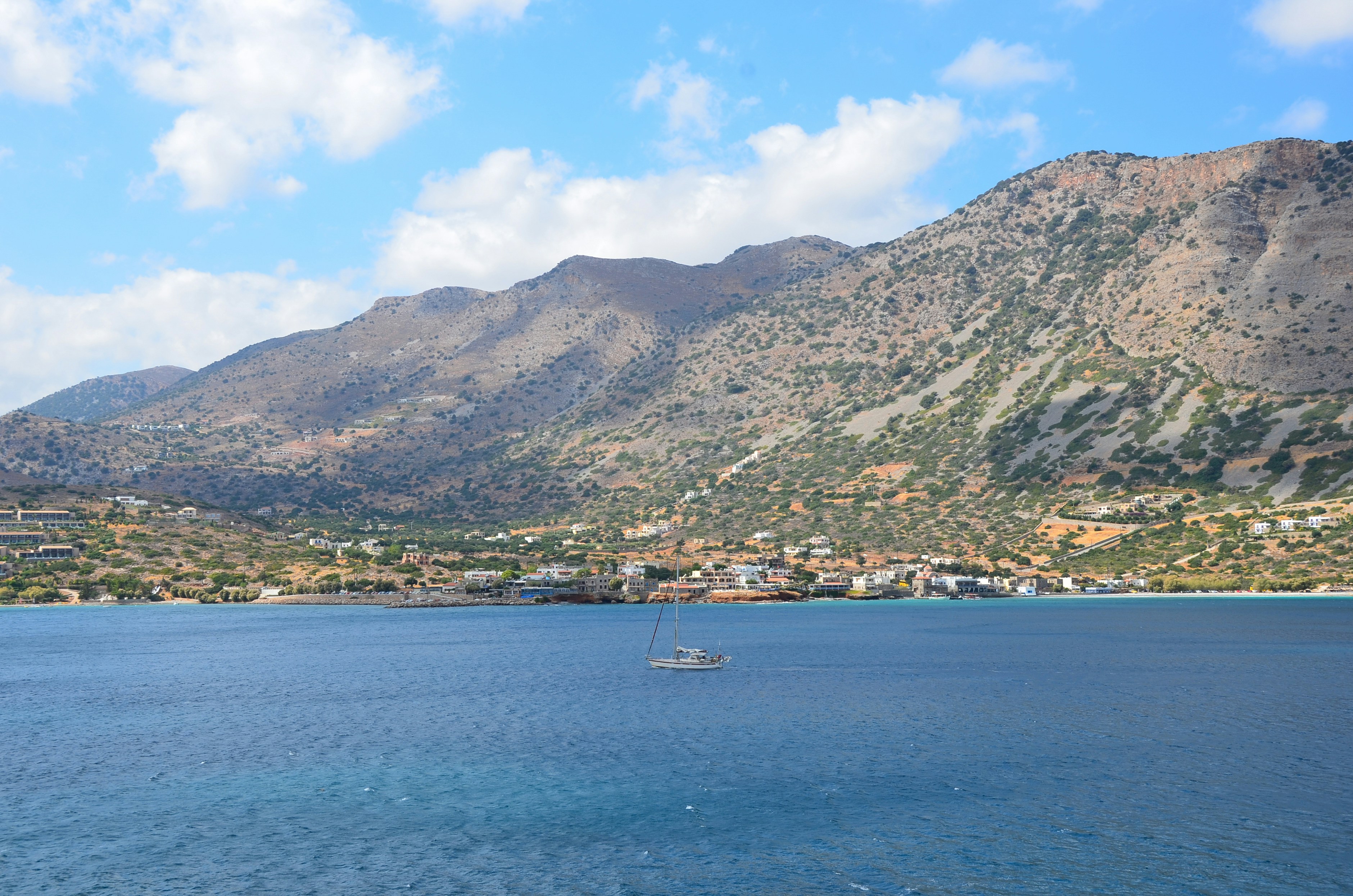 white boat on sea near mountain during daytime
