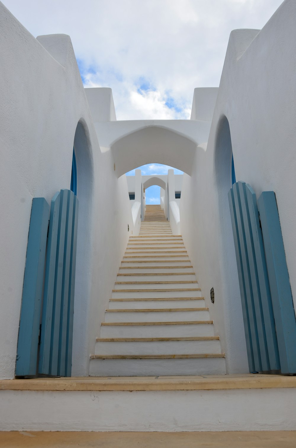 昼間の青空に浮かぶ白いコンクリートの階段